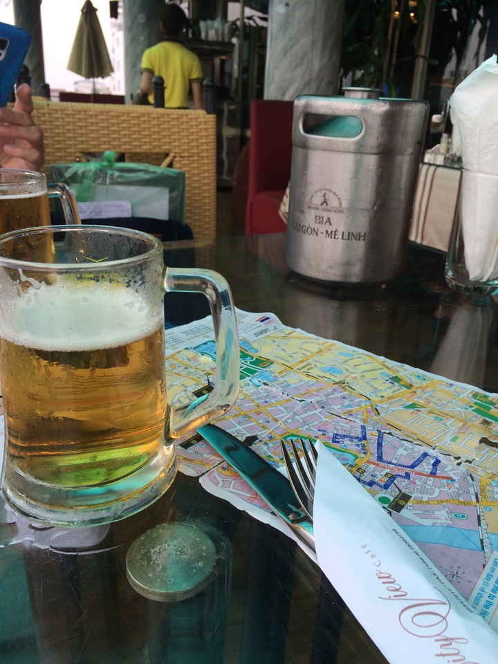 Un verre de bière sur une table avec une carte, un seau à glace et des ustensiles.
