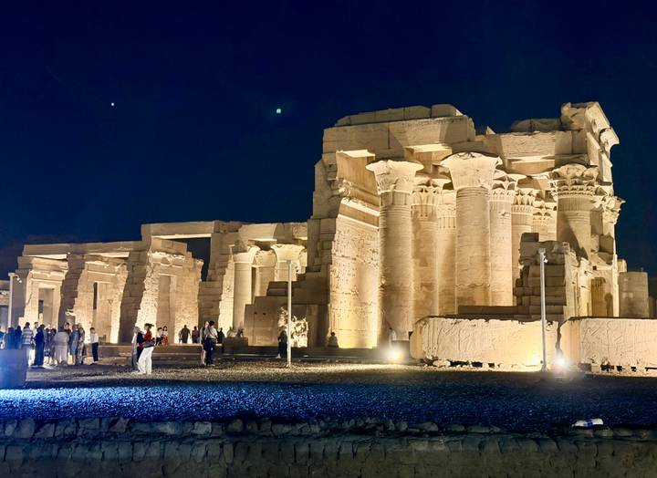 Nighttime illumination of Kom Ombo Temple with stargazing visitors.
