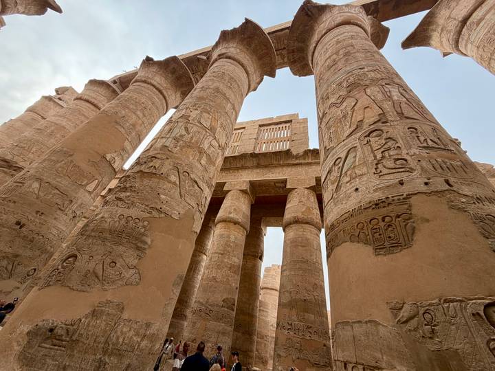 Low-angle shot of hieroglyph-laden columns towering in Karnak.