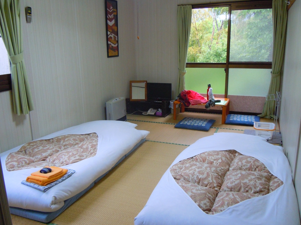 Chambre japonaise traditionnelle avec futons et tatamis.