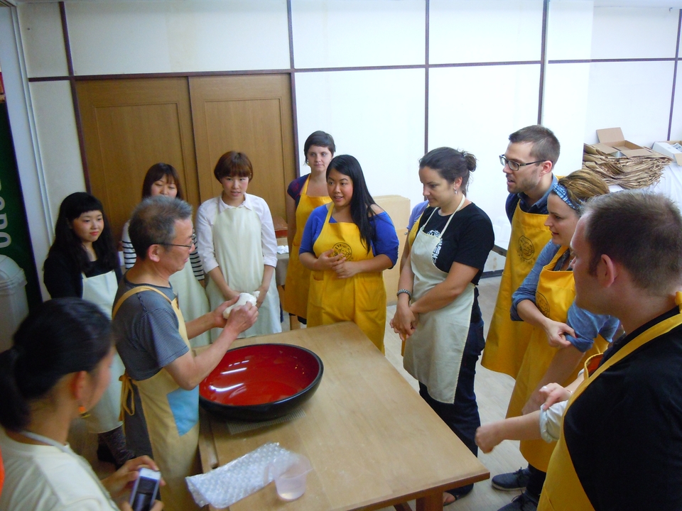 Un groupe de personnes apprenant à faire de la pâte dans un atelier.