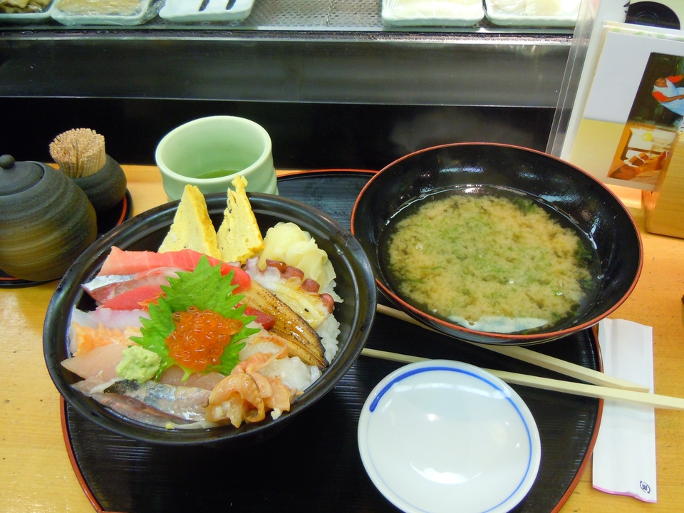 Cuisine japonaise avec sushi et soupe miso servis sur un plateau.