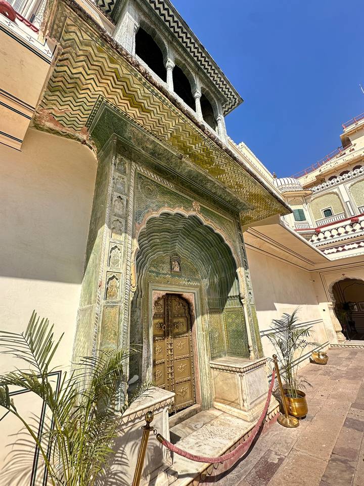 Ornate green Peacock Gate with intricate carvings and a gilded doorway at Jaipur City Palace