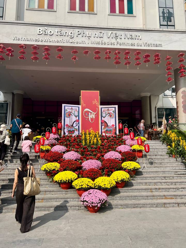 Entrance stairway decorated with vibrant flowers and Tet banners during a festival.