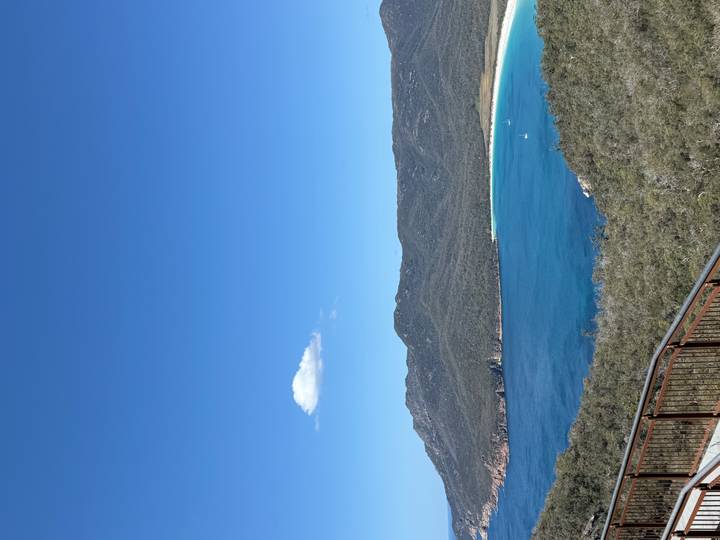A sweeping viewpoint overlooks Wineglass Bay's brilliant blue waters and white-sand beach.