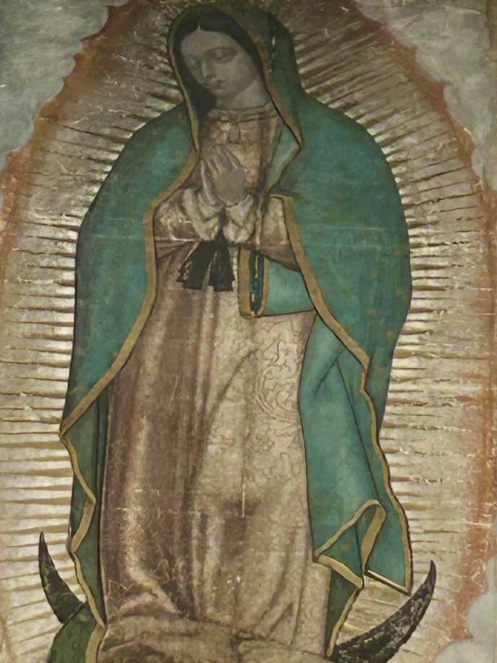 Close-up photograph of the revered image of Our Lady of Guadalupe with aged textures.