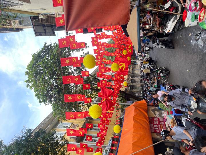 Old Quarter street festooned with bright red Vietnamese and hammer-and-sickle flags and yellow lanterns.