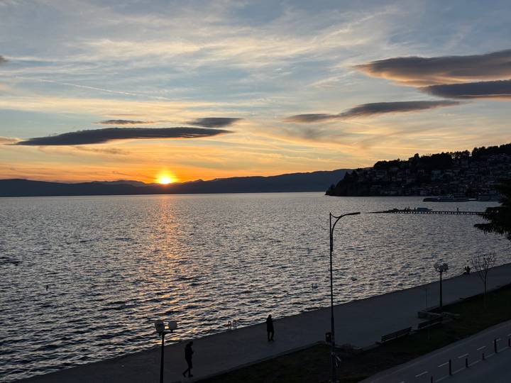 Orange sunset over Lake Ohrid with silhouetted shoreline (duplicate).
