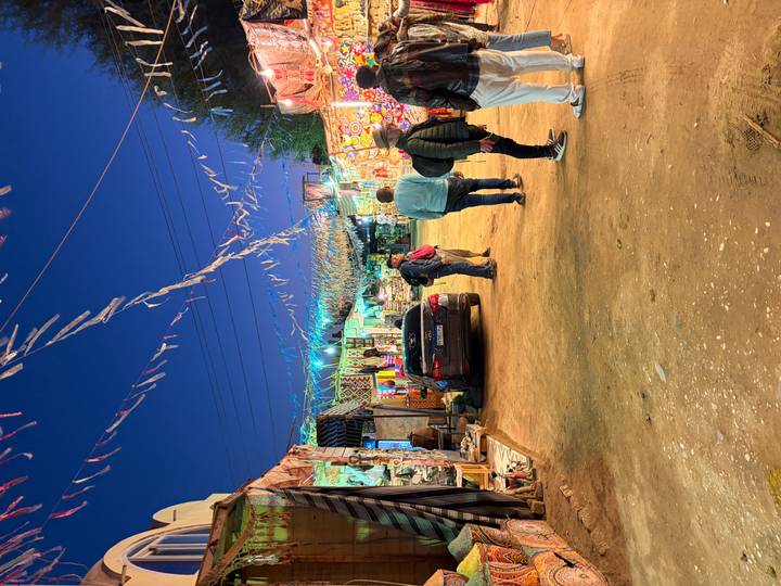 Colorful evening market street with locals and tourists browsing illuminated stalls