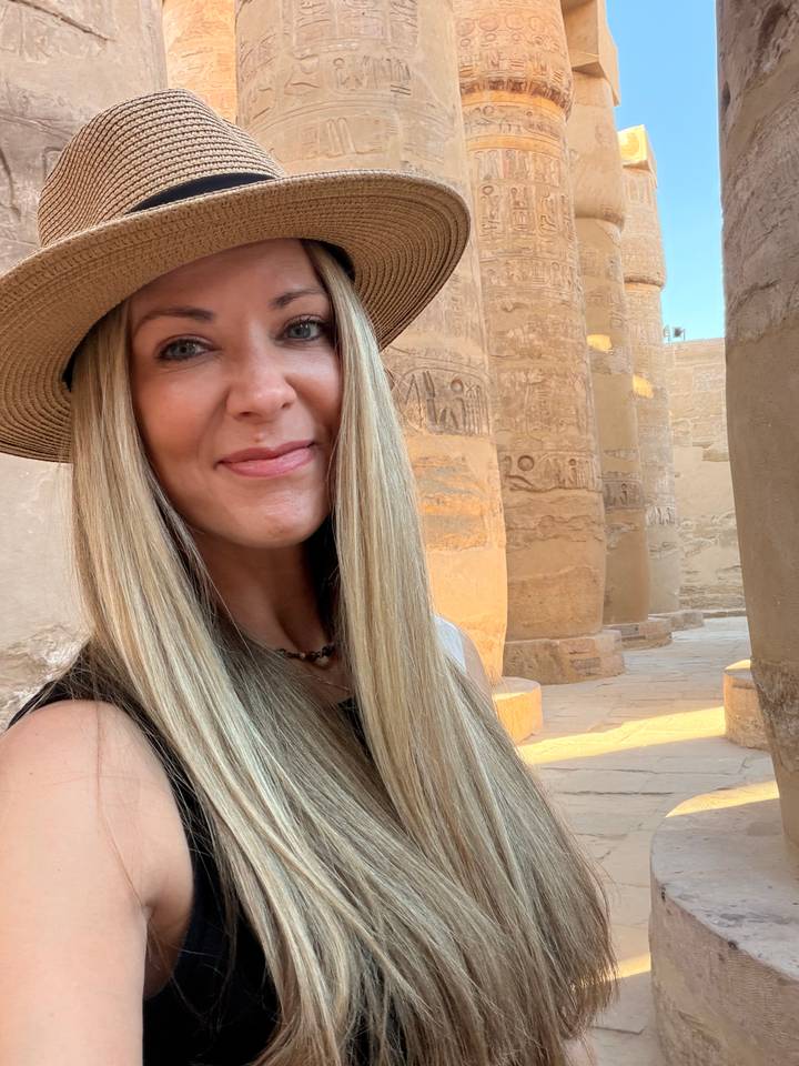 Close-up selfie of a woman inside an ancient stone columned hall