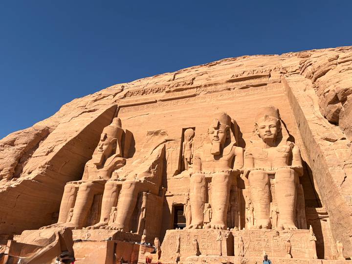 Grand statues of Ramses II carved into the rock face at Abu Simbel temple complex