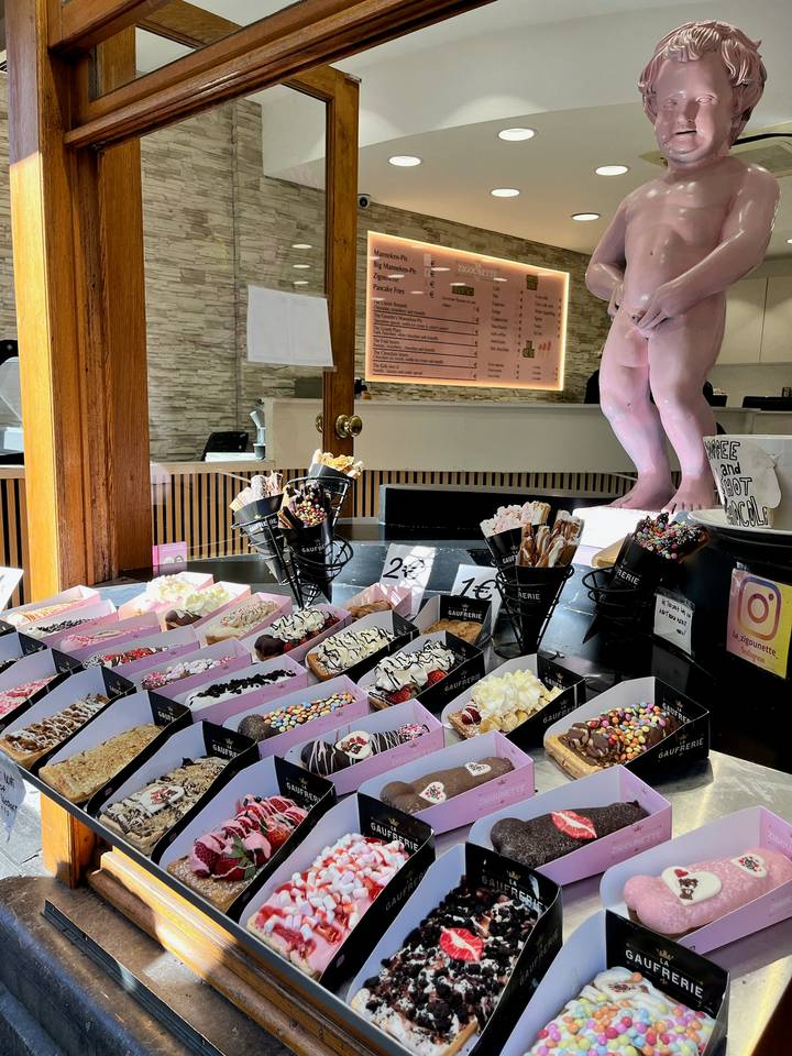 Display of decorated Belgian waffles and toppings inside a sweets shop.