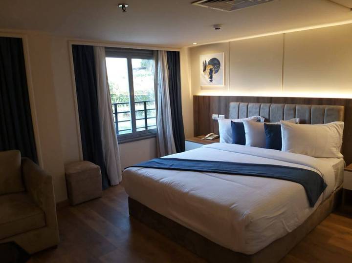 Cozy hotel bedroom with large bed, blue runner and soft ambient lighting