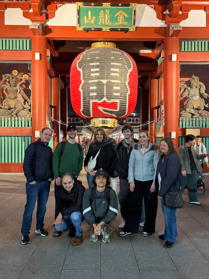 Group posing beneath the giant red lantern at the Kaminarimon gate of Senso-ji Temple in Tokyo.