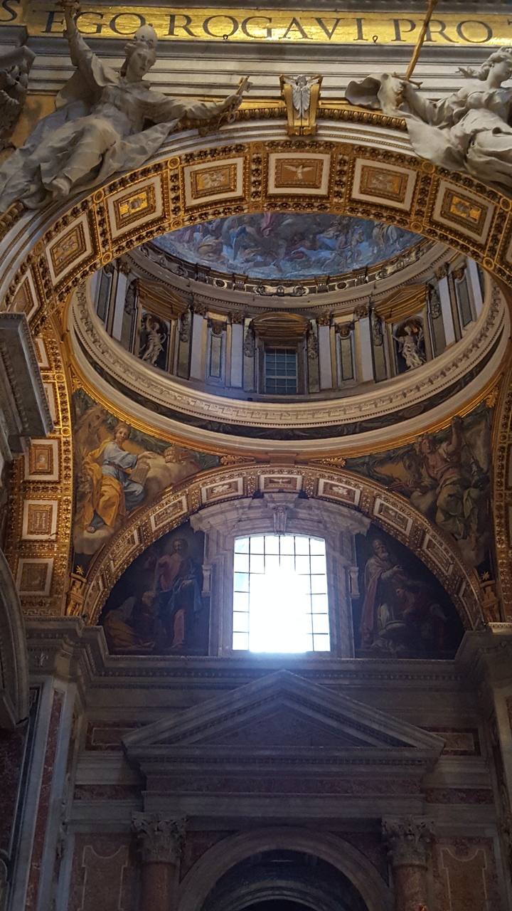Interior of St. Peter's Basilica with ornate frescoes and architecture.