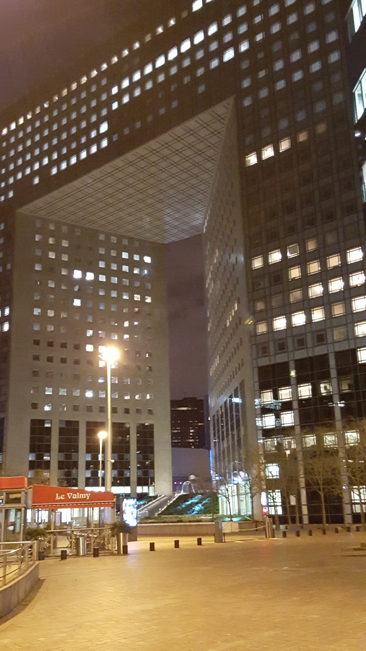 Immeubles de bureaux modernes illuminés la nuit.
