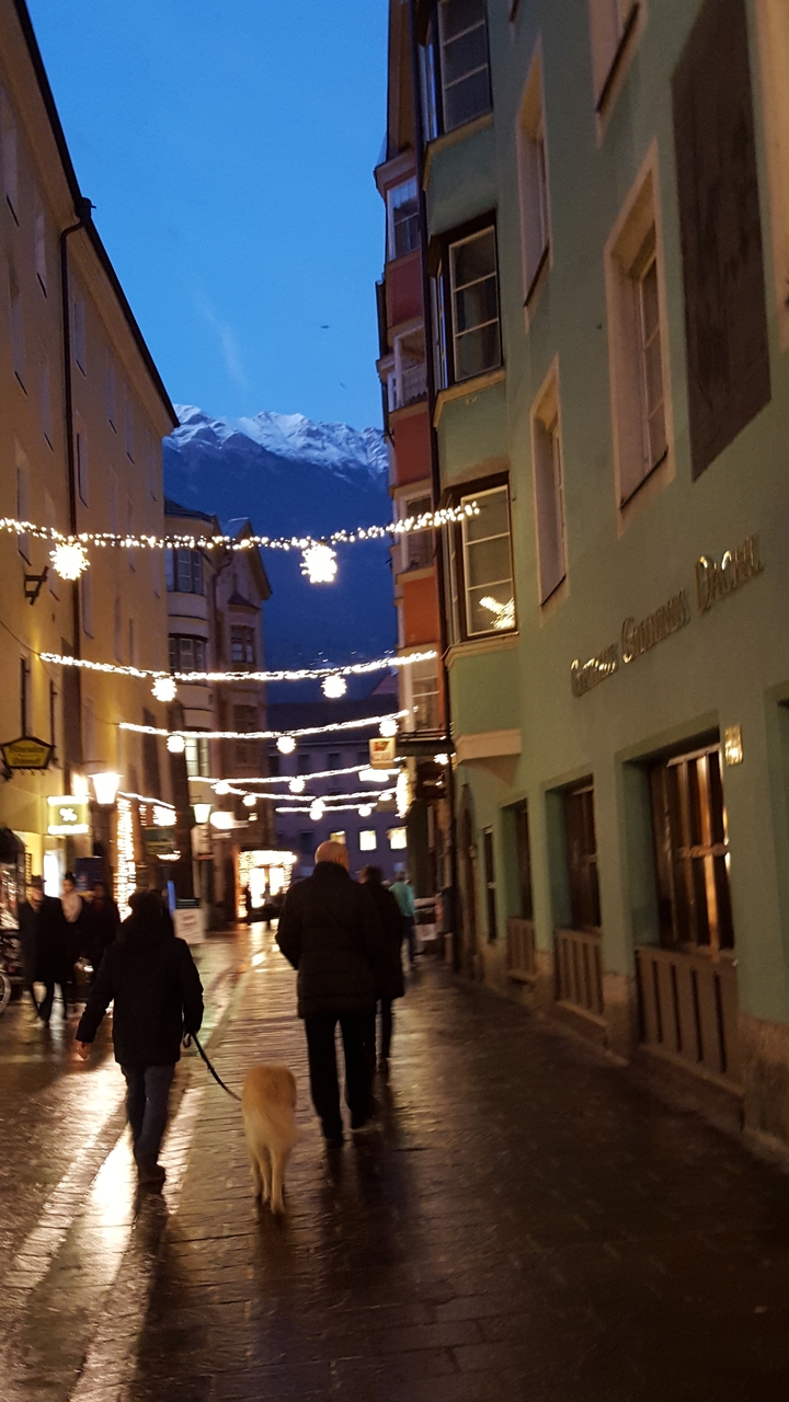 Une rue décorée de lumières festives le soir.
