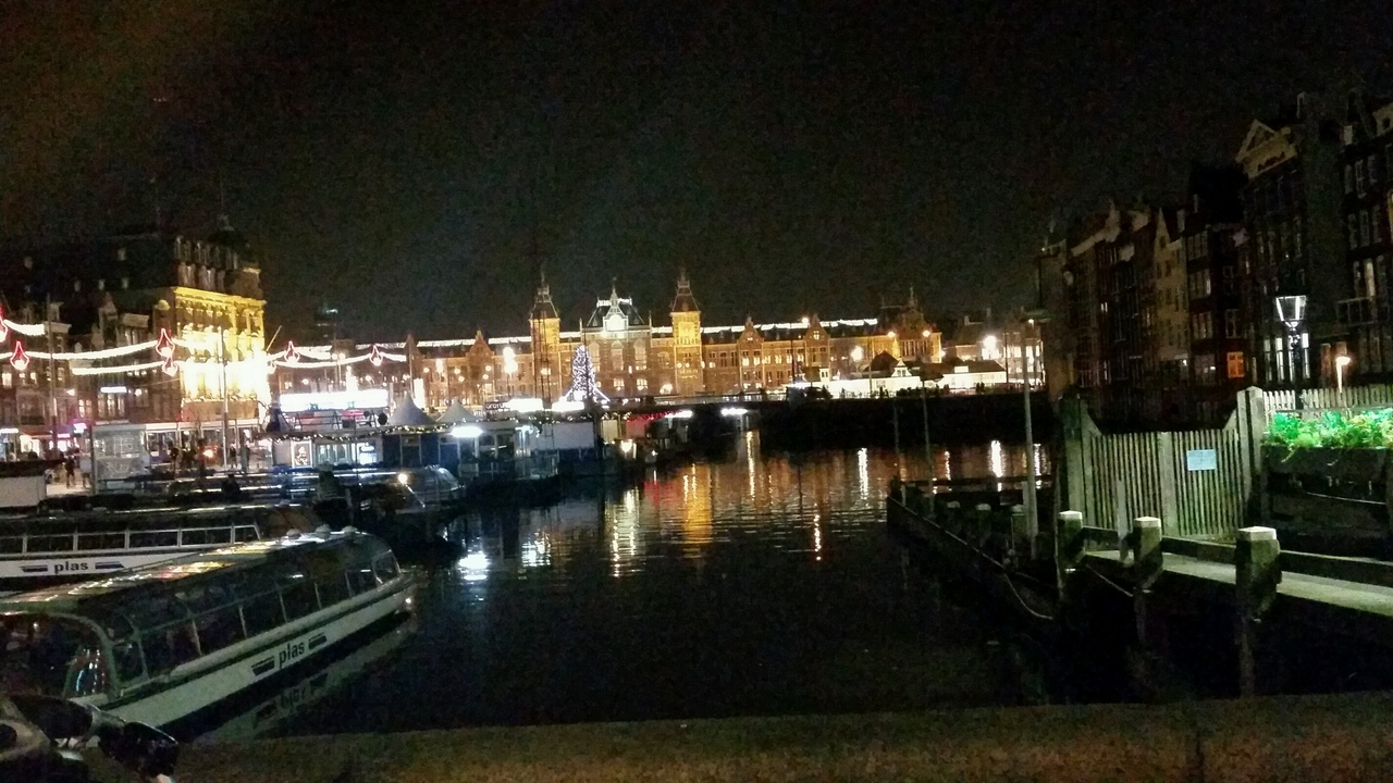 Night scene of Amsterdam with reflections on water.