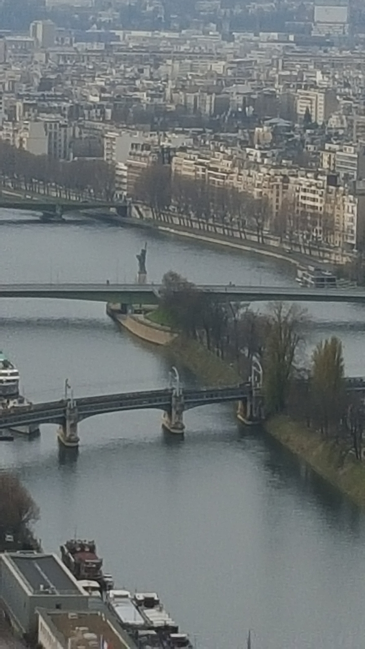 Rivière avec ponts et vue lointaine d'une petite statue de la Liberté.