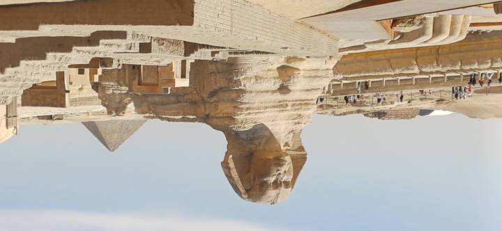 Classic desert view of the Sphinx with pyramid backdrop captured on a clear day.