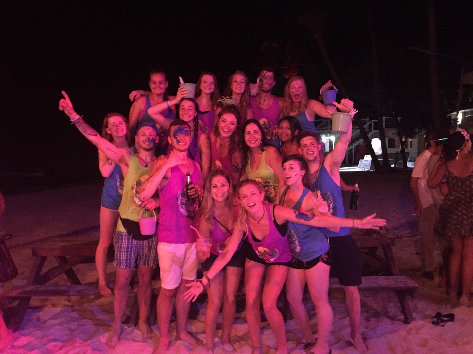 A group of people partying on the beach at night.
