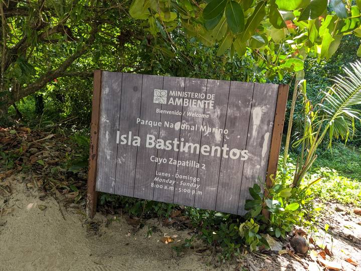 Wooden welcome sign for Parque Nacional Marino Isla Bastimentos set in tropical greenery.