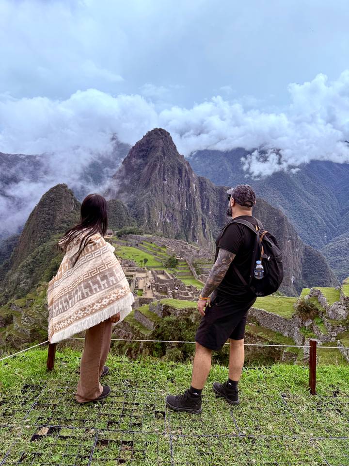 Back-view of couple gazing over the Machu Picchu citadel from a high viewpoint.