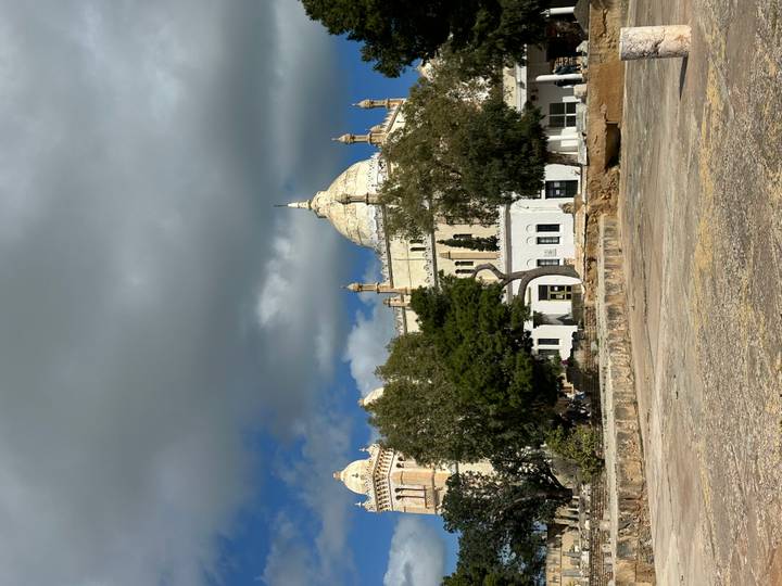Historic domed building with Moorish architecture framed by dramatic clouds in Tunisia.