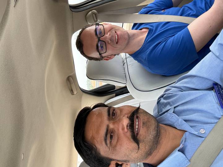 Casual selfie of two men inside a moving car on a highway