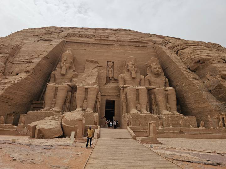 Grand façade of Abu Simbel Great Temple with four colossal seated statues of Ramses II towering over visitors.