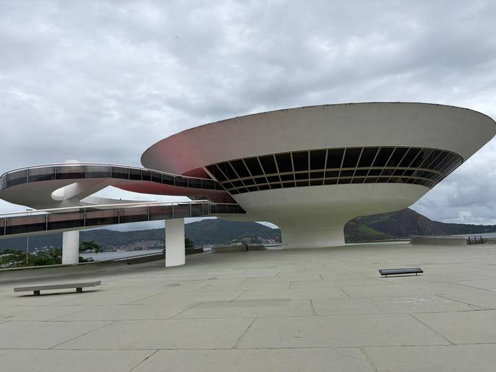 Futuristic saucer-shaped Niterói Contemporary Art Museum against cloudy skies.
