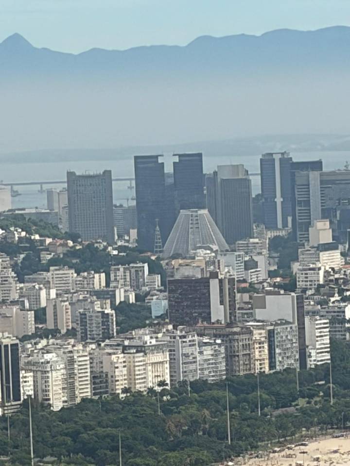Distant telephoto of Rio's downtown skyscrapers and modern cathedral on a hazy day.