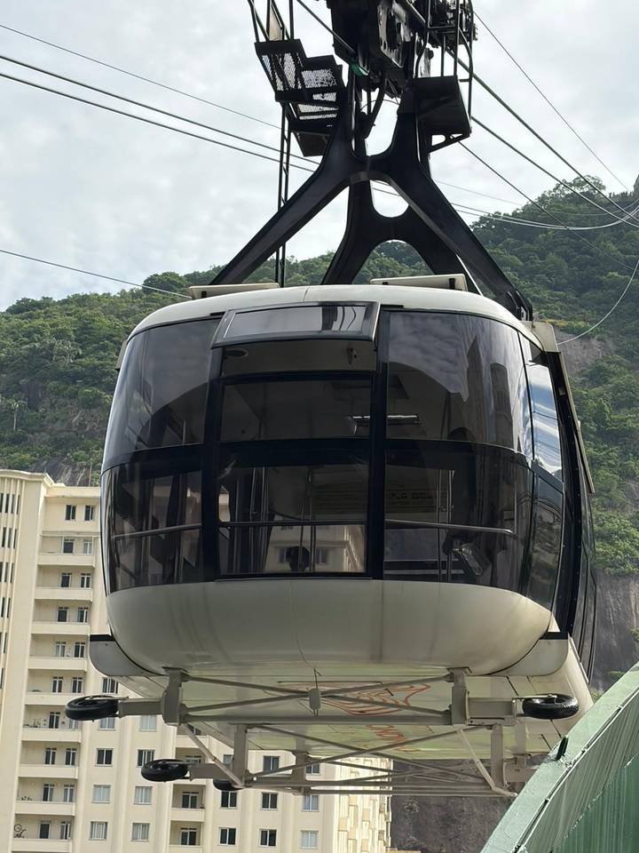 Close-up of Sugarloaf cable car cabin with lush hillside background.