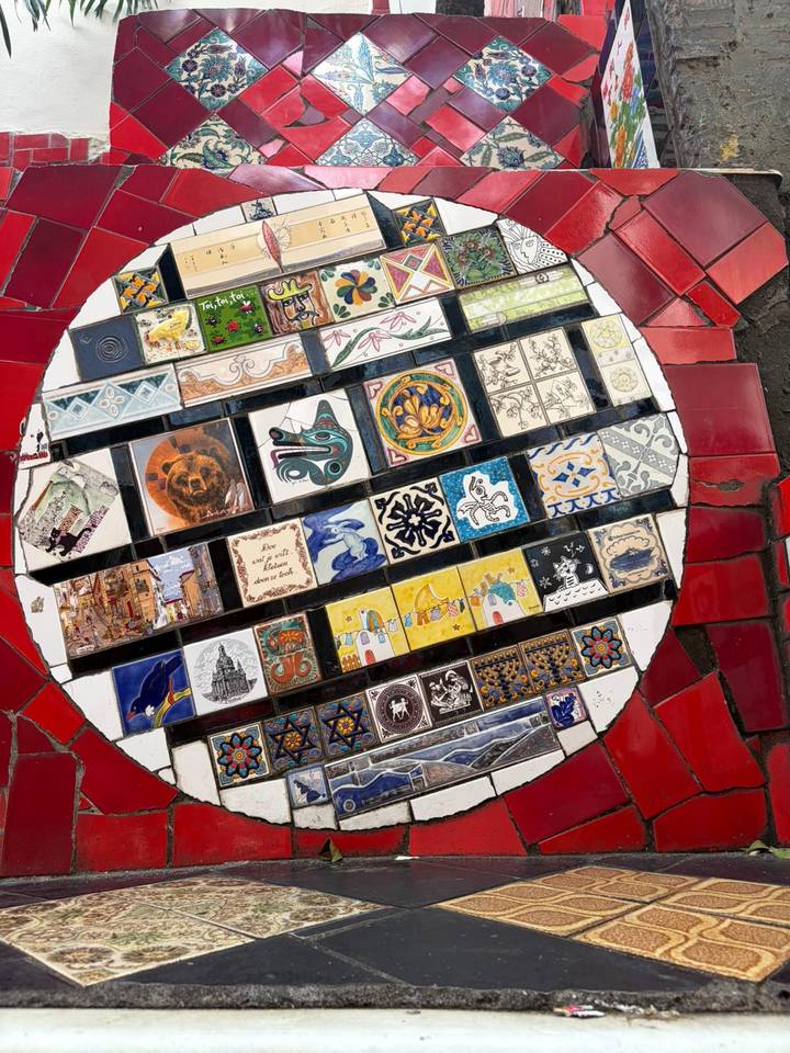 Circular mosaic of colorful hand-painted tiles displayed on the Selarón Steps landing.