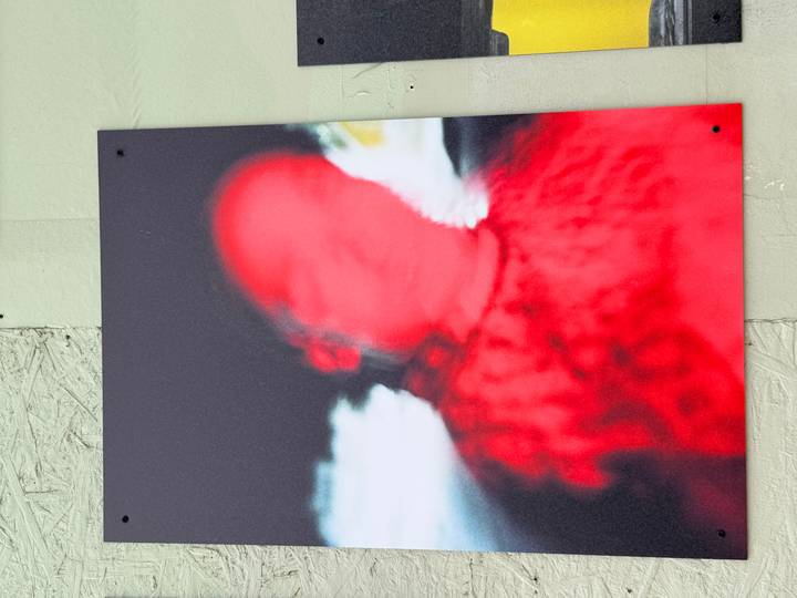 Abstract street-art photograph showing a blurry red human figure against a dark background.