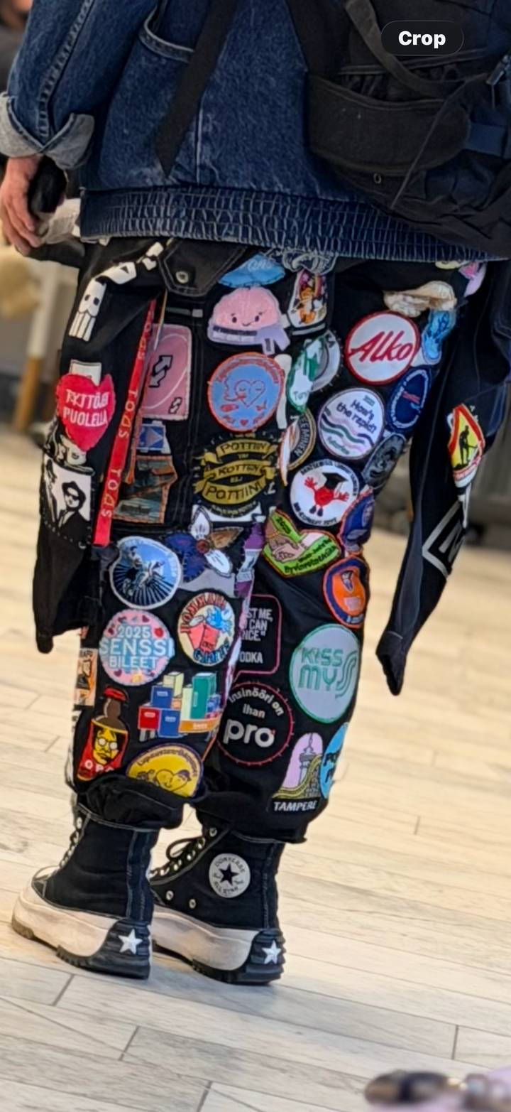 Close-up of a jacket covered in colourful embroidered patches, slightly out of focus.