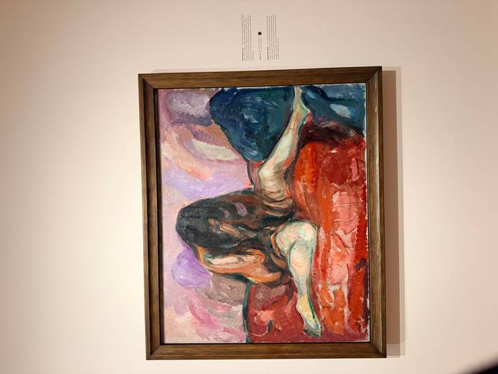 Framed expressionist artwork of a reclining figure showcased on a neutral gallery wall