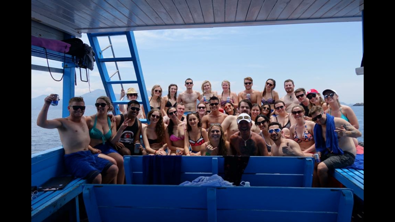 Groupe de personnes posant sur un bateau en mer.