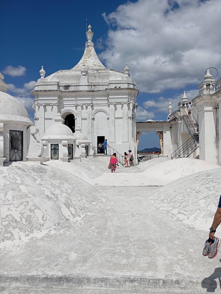White domes and walkways atop León Cathedral with visitors exploring under a bright sky