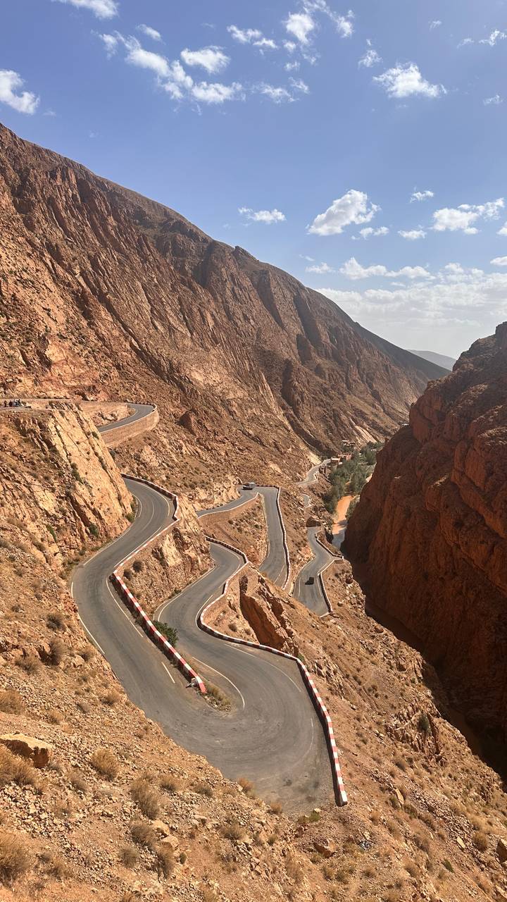 Winding mountain road snaking through steep red rock walls of Dades Gorge