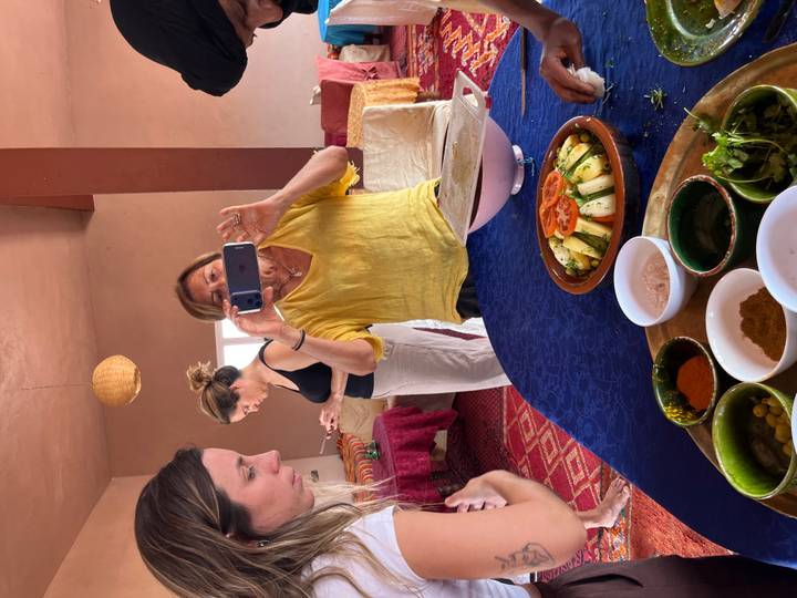Participants photographing ingredients during a Moroccan cooking class in a traditional room