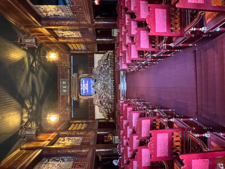 Ornate royal theatre hall lined with red velvet chairs inside Hue Citadel.