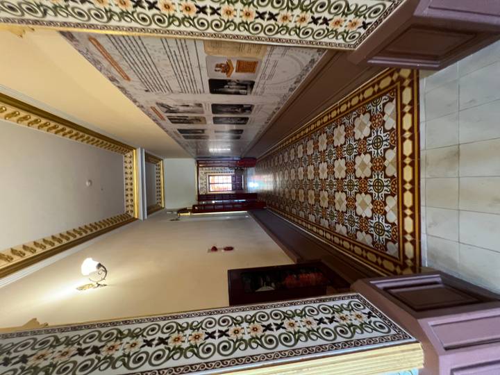 Elegant palace corridor with patterned tiled floor and soft lighting.