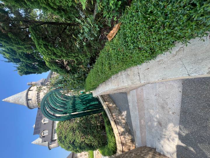 Garden walkway with trimmed hedges and an arched green trellis at Ba Na Hills.