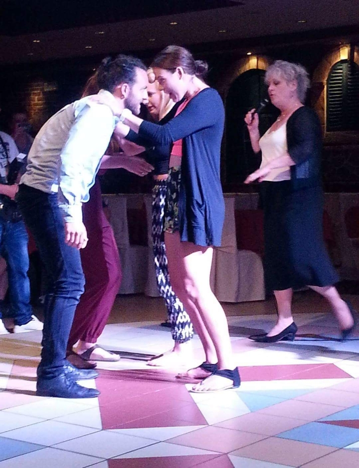 Des personnes dansent dans une pièce faiblement éclairée.