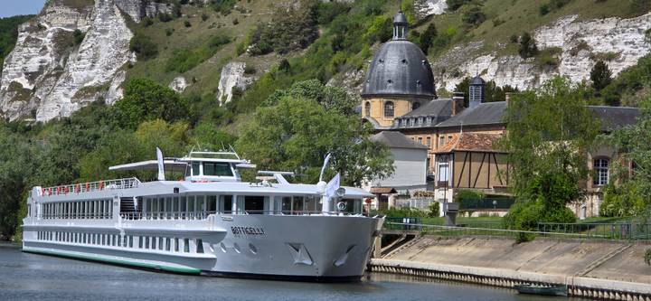 Close-up of cruise ship Botticelli against limestone cliffs and domed chapel.