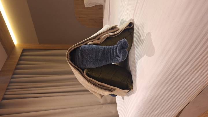 Playful towel elephant sculpture arranged on a neatly made hotel bed.