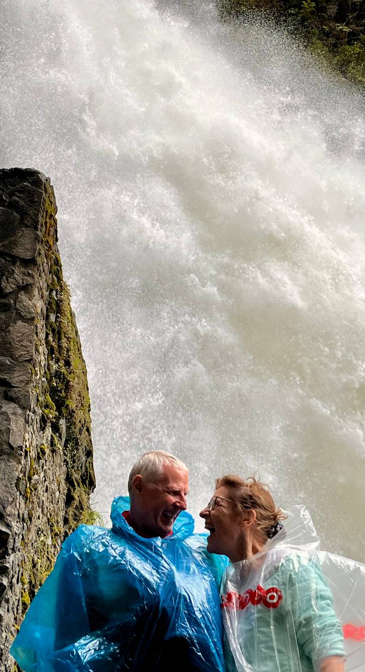 Close-up view of rushing waterfall spray against a rocky wall.