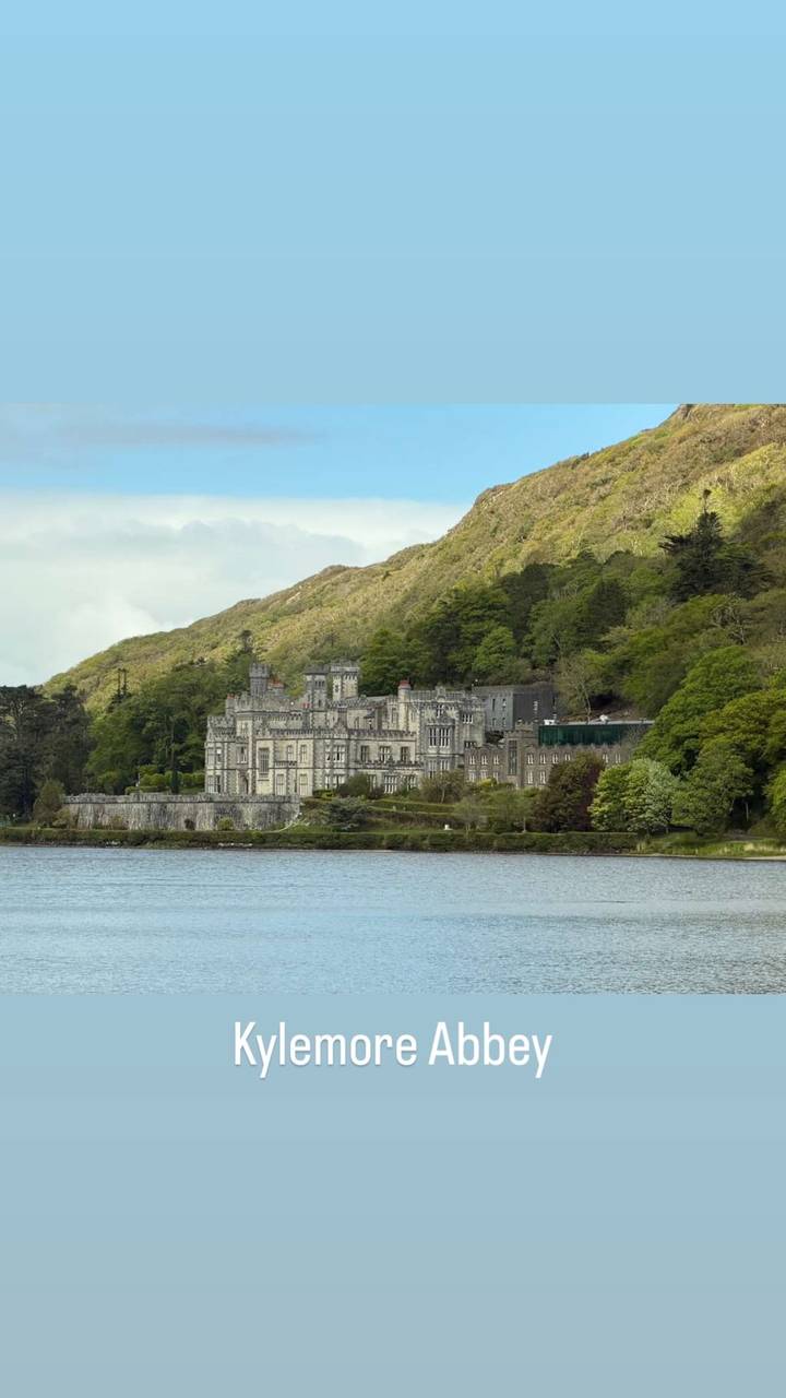 Historic Kylemore Abbey nestled among forested hills reflected softly in a lake