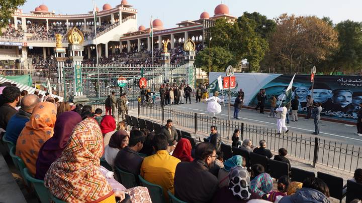 Crowds watch the Wagah border ceremony from stadium seating as soldiers perform in the parade ground.